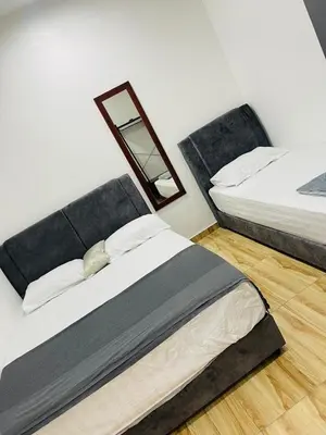 a bedroom with two beds and a mirror on the wall at The SilverCity Homestay Ipoh in Ipoh
