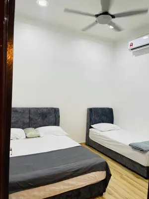 two beds sitting next to each other in a room at The SilverCity Homestay Ipoh in Ipoh