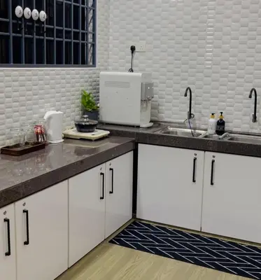 a kitchen with white cabinets and a sink at The SilverCity Homestay Ipoh in Ipoh