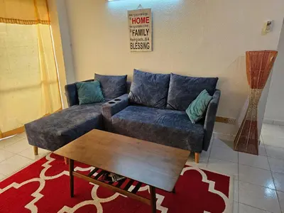 a living room with a couch and a coffee table at Bintara Guesthouse Sri Sayang Batu Ferringhi in Batu Ferringhi