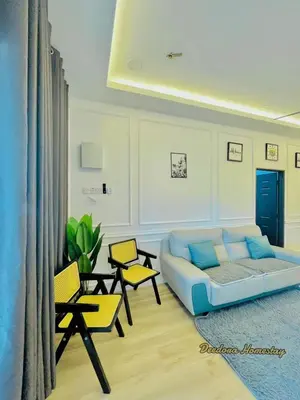 a living room with a blue couch and chairs at Homestay DEEDORA in Seri Manjung