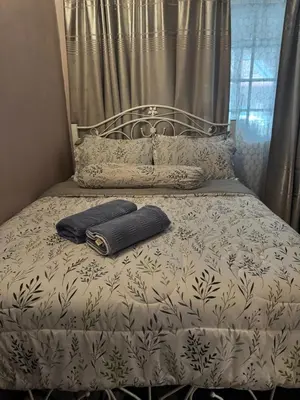 a bed with two pillows and a suitcase on it at NuLya Homestay in Kepala Batas