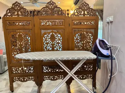 a wooden cabinet with a stool in front of it at NuLya Homestay in Kepala Batas