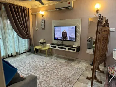 a living room with a flat screen tv on a wall at NuLya Homestay in Kepala Batas