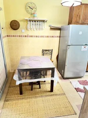 a kitchen with a table and a refrigerator at NuLya Homestay in Kepala Batas