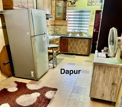 a kitchen with a stainless steel refrigerator and a rug at NuLya Homestay in Kepala Batas