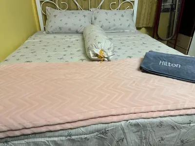 a bed with a pillow and a book on it at NuLya Homestay in Kepala Batas