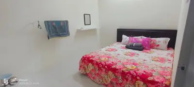 a bedroom with a bed with a red comforter at D'Iman UTP Seri Iskandar Homestay in Kampung Bota Kiri