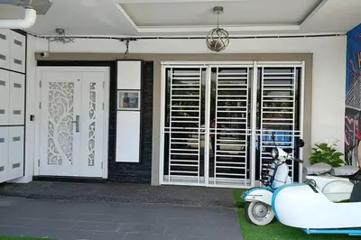a blue scooter parked in front of a house at H&H Homestay Premium House in Kepala Batas