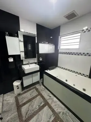 a bathroom with a bath tub and a sink at H&H Homestay Premium House in Kepala Batas
