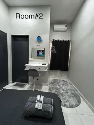 a room with a tv and a bed and a desk at Matsurika Guest House - Kulim in Kulim