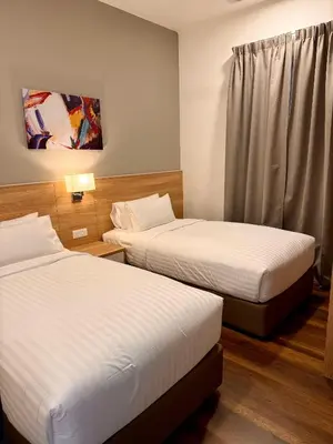a hotel room with two beds and a window at Sunway Onsen Suite in Tambun