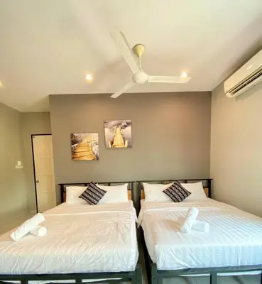 two beds in a room with a ceiling fan at LYL Journey House at Ipoh Town Centre 17PAX 6BR in Ipoh