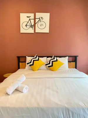 a bed with yellow and black and white pillows at LYL Journey House at Ipoh Town Centre 17PAX 6BR in Ipoh