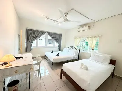 a hotel room with two beds and a table and chairs at K Inn 55 in George Town