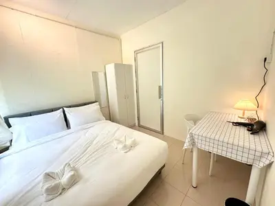 a bedroom with a large white bed and a table at K Inn 55 in George Town