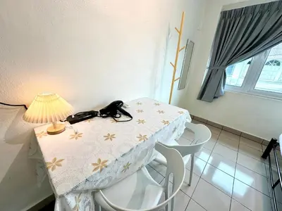 a table with a lamp on top of it with chairs at K Inn 55 in George Town