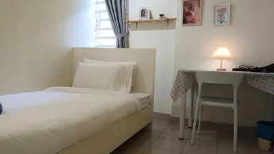 a small bedroom with a bed and a desk at K Inn 55 in George Town