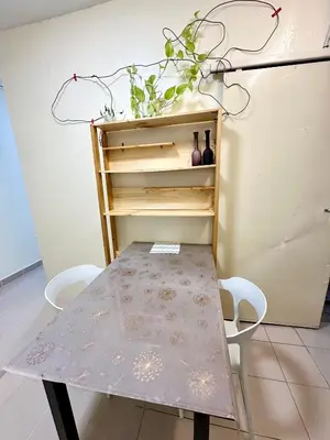 a table and chairs in a room with a shelf at K Inn 55 in George Town