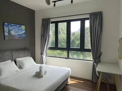 a bedroom with a bed and a large window at ONSTAY Sunway Onsen Suites in Ipoh