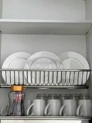 a shelf in a refrigerator filled with dishes and cups at ONSTAY Sunway Onsen Suites in Ipoh