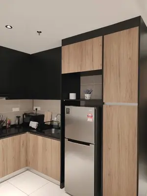 a kitchen with a refrigerator and wooden cabinets at ONSTAY Sunway Onsen Suites in Ipoh