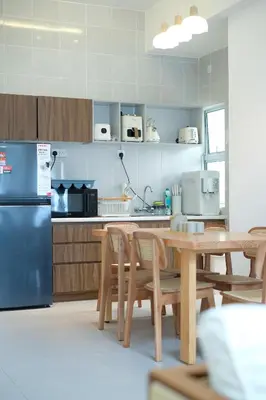 a kitchen with a table and a refrigerator at Bunny's Warm Penthouse by Comfy Sofy in Brinchang