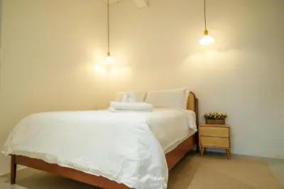 a bedroom with a bed with white sheets and two lights at Bunny's Warm Penthouse by Comfy Sofy in Brinchang