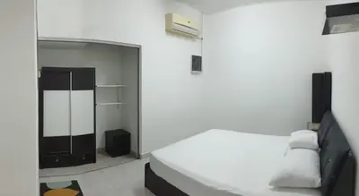 a white bedroom with a bed and a closet at Nuha Kulim Hitech Homestay Islamic in Kulim
