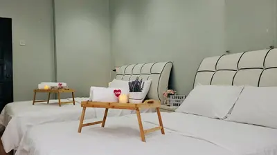 two beds with white sheets and a table on top at Cameron Brinchang 5 Min to Centrum 12pax Duplex Shophouse by City Home Empire in Brinchang