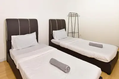 two twin beds in a room with two pillows at Crystal Creek 3BR Condo near Taiping Lake Garden & Zoo with WiFi Netflix in Taiping