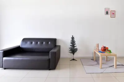 a black leather couch in a living room with a table at Crystal Creek 3BR Condo near Taiping Lake Garden & Zoo with WiFi Netflix in Taiping