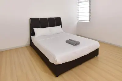 a bed with a black frame and a pillow on it at Crystal Creek 3BR Condo near Taiping Lake Garden & Zoo with WiFi Netflix in Taiping