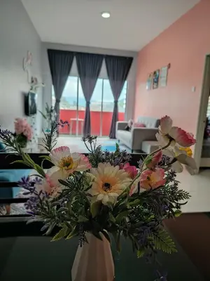 a vase of flowers on a table in a living room at DLAZ HOMESTAY in Tanah Rata