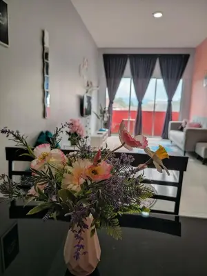 a vase of flowers on a table in a living room at DLAZ HOMESTAY in Tanah Rata