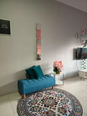 a living room with a blue couch and a rug at DLAZ HOMESTAY in Tanah Rata