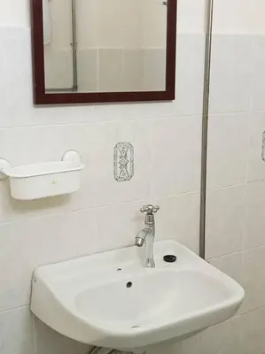 a bathroom with a white sink and a mirror at Taman Sunway Tunas in Bayan Lepas