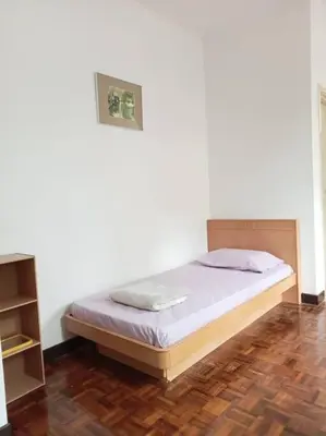 a bed in a room with a white wall at Taman Sunway Tunas in Bayan Lepas