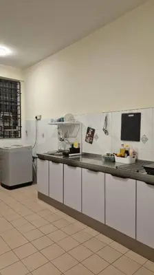 a kitchen with white cabinets and a counter top at Taman Sunway Tunas in Bayan Lepas