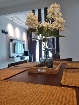 a vase with flowers on a table in a room at NuTiQa Homestay Meru Ipoh Perak in Ipoh