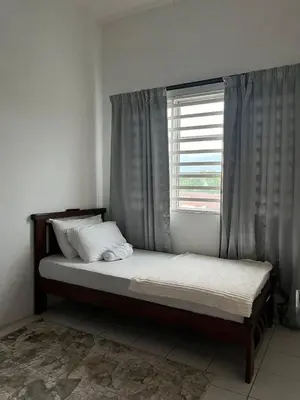 a bed sitting in a room with a window at Dsyahna homestay in Ipoh