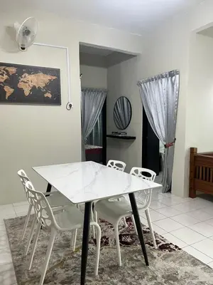 a dining room with a white table and chairs at Dsyahna homestay in Ipoh