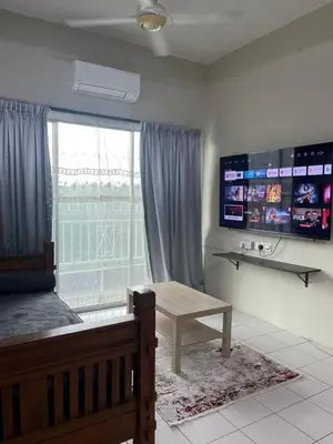 a bedroom with a bed and a table and a window at Dsyahna homestay in Ipoh