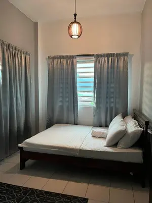 a bed sitting in a room with a window at Dsyahna homestay in Ipoh
