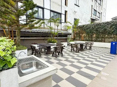 a patio with picnic tables and chairs and a building at The Retreat Mountain n Sunrise view Hilltop Hotel Apartment in Cameron Highlands in Brinchang