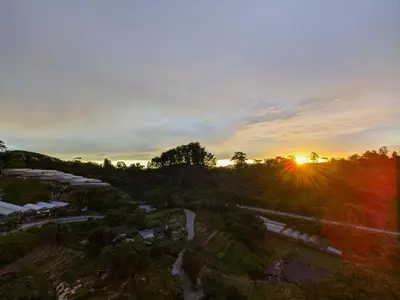 an overhead view of the sun setting over a forest at The Retreat Mountain n Sunrise view Hilltop Hotel Apartment in Cameron Highlands in Brinchang