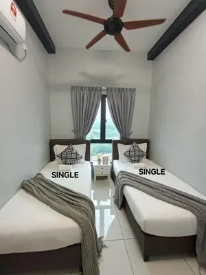 two beds in a room with a ceiling fan at The Horizon Ipoh Belle Vue by Grab A Stay in Ipoh