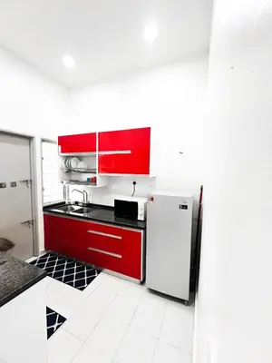 a kitchen with red cabinets and a refrigerator at JaszSpace at Kulim Hi-Tech - All Room Aircond,Wifi,Netflix in Kulim