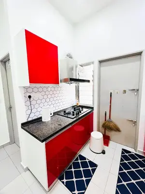 a red and white kitchen with a stove top oven at JaszSpace at Kulim Hi-Tech - All Room Aircond,Wifi,Netflix in Kulim