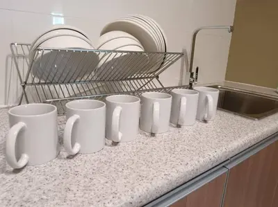 a row of white coffee cups sitting on a counter at The Horizon Ipoh Dual L13A by Grab A Stay in Ipoh